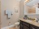 Bathroom featuring tile floors, dark wood cabinets, and granite countertops at 10765 Village Lake Rd, Windermere, FL 34786