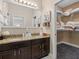 Bathroom featuring a granite countertop, double sinks, and view into a walk-in closet at 10765 Village Lake Rd, Windermere, FL 34786
