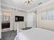 Bedroom with gray carpet, a light wood bed frame, and a TV on a dresser at 10765 Village Lake Rd, Windermere, FL 34786