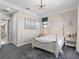 Cozy bedroom featuring gray carpet, a light wood bed frame, and a stylish light fixture at 10765 Village Lake Rd, Windermere, FL 34786