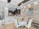Dining area with stone accent wall adjacent to modern kitchen, complete with elegant place settings at 10765 Village Lake Rd, Windermere, FL 34786