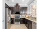 Well-equipped kitchen with granite countertops, stainless steel appliances, and stylish dark cabinetry at 10765 Village Lake Rd, Windermere, FL 34786