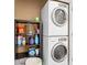 Laundry room featuring a stacked washer and dryer, and shelving for storage at 10765 Village Lake Rd, Windermere, FL 34786