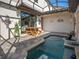 Inviting screened-in pool area with stone tile, a picnic table and charming water features at 10765 Village Lake Rd, Windermere, FL 34786