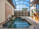 Relaxing screened-in pool area with elegant water features and a tiled patio at 10765 Village Lake Rd, Windermere, FL 34786