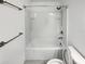 Full white bathtub and shower combination with chrome fixtures and white tiled walls at 1112 Merrill St, Davenport, FL 33837