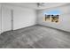 Spacious bedroom featuring plush carpet, a ceiling fan, and a large window overlooking construction at 1112 Merrill St, Davenport, FL 33837