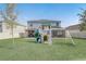 Spacious backyard featuring a playset, screened patio, and covered patio at 11279 Amber Ridge Dr, Zellwood, FL 32798