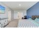 Large bedroom featuring a blue accent wall, carpet, ensuite bathroom, and a television at 11279 Amber Ridge Dr, Zellwood, FL 32798