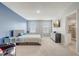 Spacious bedroom features a blue accent wall, plush carpet, and an ensuite bathroom at 11279 Amber Ridge Dr, Zellwood, FL 32798