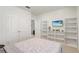 Bright bedroom featuring neutral walls, large closet, and stylish white shelving units at 11279 Amber Ridge Dr, Zellwood, FL 32798