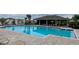 Relaxing community pool with ample seating, covered lounge area, and meticulously brick-laid pool deck at 11279 Amber Ridge Dr, Zellwood, FL 32798