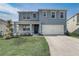 Charming two-story home featuring a well-manicured lawn, two car garage, and delightful exterior at 11279 Amber Ridge Dr, Zellwood, FL 32798