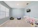 Bright flex room featuring carpet, a window, and view to a tv and storage unit at 11279 Amber Ridge Dr, Zellwood, FL 32798