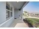 Welcoming covered front porch with modern gray walls, providing curb appeal and shade at 11279 Amber Ridge Dr, Zellwood, FL 32798