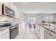 Kitchen with stainless steel appliances, white cabinetry, granite counters and an adjacent dining area at 11279 Amber Ridge Dr, Zellwood, FL 32798