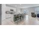 Open kitchen with white cabinets, a granite island with barstool seating and stainless steel appliances at 11279 Amber Ridge Dr, Zellwood, FL 32798