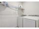 A clean laundry room featuring a modern, front-loading washer and dryer and shelving at 11279 Amber Ridge Dr, Zellwood, FL 32798