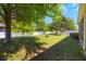 Spacious backyard featuring a lush lawn, mature trees, and a pristine white fence for privacy at 1155 Seburn Rd, Apopka, FL 32703