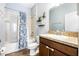 Well-lit bathroom with a granite countertop, a vanity, and a tub-shower combination with a floral shower curtain at 1155 Seburn Rd, Apopka, FL 32703