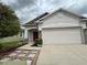 Charming single Gathering home featuring a red front door and a two car garage at 118 Hurst Ct, Deland, FL 32724