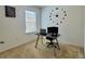 Carpeted office space with a modern desk, clock, and natural light from a window at 118 Hurst Ct, Deland, FL 32724