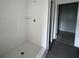 White tiled shower with glass shelf and hexagon tile floor at 13528 Autumn Harvest Ave, Winter Garden, FL 34787