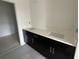 Modern bathroom featuring dual sinks, dark cabinetry, and bright white countertops at 13528 Autumn Harvest Ave, Winter Garden, FL 34787
