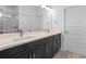 Modern bathroom featuring double sinks, white countertops, dark wood cabinets, and glass-enclosed shower at 13528 Autumn Harvest Ave, Winter Garden, FL 34787