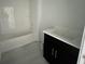 Bright bathroom showcasing a white subway tile shower and a dark vanity with a white countertop at 13528 Autumn Harvest Ave, Winter Garden, FL 34787