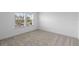 Bright bedroom with neutral carpet, white walls, and two windows with a view at 13528 Autumn Harvest Ave, Winter Garden, FL 34787