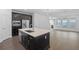 Kitchen with stainless steel appliances, an island with quartz countertop, and dark cabinets at 13528 Autumn Harvest Ave, Winter Garden, FL 34787