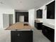 Modern kitchen with black cabinetry, a spacious island with a paper top, and stainless steel appliances at 13528 Autumn Harvest Ave, Winter Garden, FL 34787