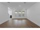 Spacious living room with hardwood flooring, three large windows, and neutral walls at 13528 Autumn Harvest Ave, Winter Garden, FL 34787