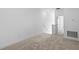 Spacious living room with neutral carpet and white walls leading to a stairwell at 13528 Autumn Harvest Ave, Winter Garden, FL 34787