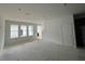 A spacious living room has three windows and a door inside the home at 13528 Autumn Harvest Ave, Winter Garden, FL 34787