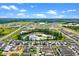 Expansive aerial view of a residential neighborhood with a central pond and lush green surroundings at 13536 Autumn Harvest Ave, Winter Garden, FL 34787