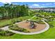 Aerial view of neighborhood playground featuring slides and lush green grass at 13536 Autumn Harvest Ave, Winter Garden, FL 34787