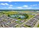 Areal view showcases a well-planned community with neatly arranged houses and a scenic pond at 13536 Autumn Harvest Ave, Winter Garden, FL 34787