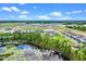 A stunning aerial view of a Primary-planned community featuring a pool, pond and new homes at 13536 Autumn Harvest Ave, Winter Garden, FL 34787