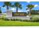 Elegant entrance sign for Harvest at Ovation, beautifully landscaped with palm trees and lush greenery at 13536 Autumn Harvest Ave, Winter Garden, FL 34787