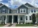 Charming townhome showcasing a beautifully landscaped yard, columned porch, and stylish two-tone exterior at 13536 Autumn Harvest Ave, Winter Garden, FL 34787