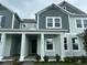 Inviting two-story townhouse with a covered front porch and Craftsman-style architectural details at 13536 Autumn Harvest Ave, Winter Garden, FL 34787