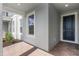 This front porch is paved with brick and features white framed windows and a dark blue front door at 13536 Autumn Harvest Ave, Winter Garden, FL 34787