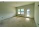 Sunlit living room featuring three windows and an exterior door, showcasing natural light and access at 13536 Autumn Harvest Ave, Winter Garden, FL 34787