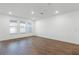 A well-lit living room boasting dark wood floors and three large windows at 13536 Autumn Harvest Ave, Winter Garden, FL 34787
