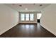 Bright living room featuring dark hardwood floors and a trio of windows, offering plenty of light at 13536 Autumn Harvest Ave, Winter Garden, FL 34787