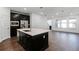 Open-concept area with kitchen island looking into the living room with wood floors at 13536 Autumn Harvest Ave, Winter Garden, FL 34787