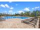Community pool with tanning chairs, umbrellas and lush green landscaping at 13536 Autumn Harvest Ave, Winter Garden, FL 34787