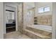 Elegant bathroom featuring a soaking tub, glass shower and tile surround at 13722 Fox Glove St, Winter Garden, FL 34787
